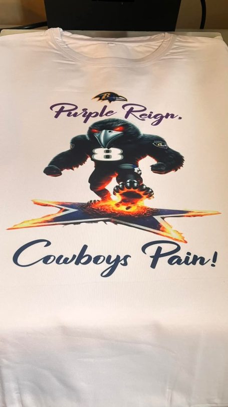 A white T-shirt featuring a muscular mascot and the text "Cowboys Pain!" in bold.