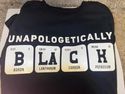 Black T-shirt with the text "UNAPOLOGETICALLY BLACK" in periodic table style.