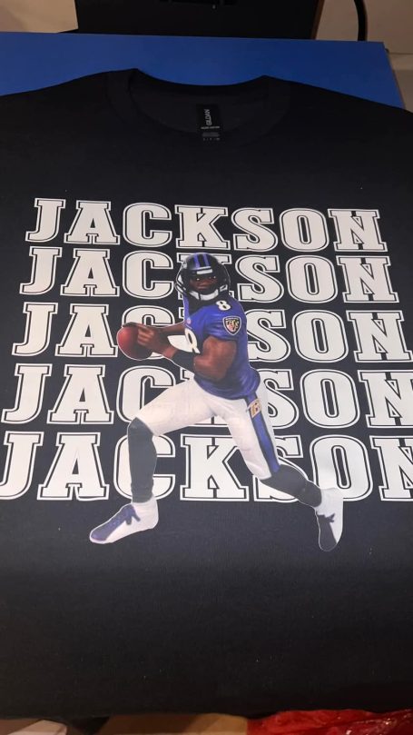 Black t-shirt featuring a player in purple uniform with "JACKSON" text repeated behind.